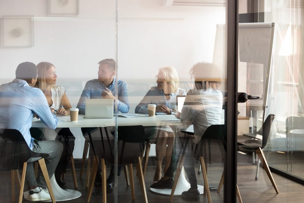 Tips for finding the right insurance provider team inside a glass room discussing the best insurance provider